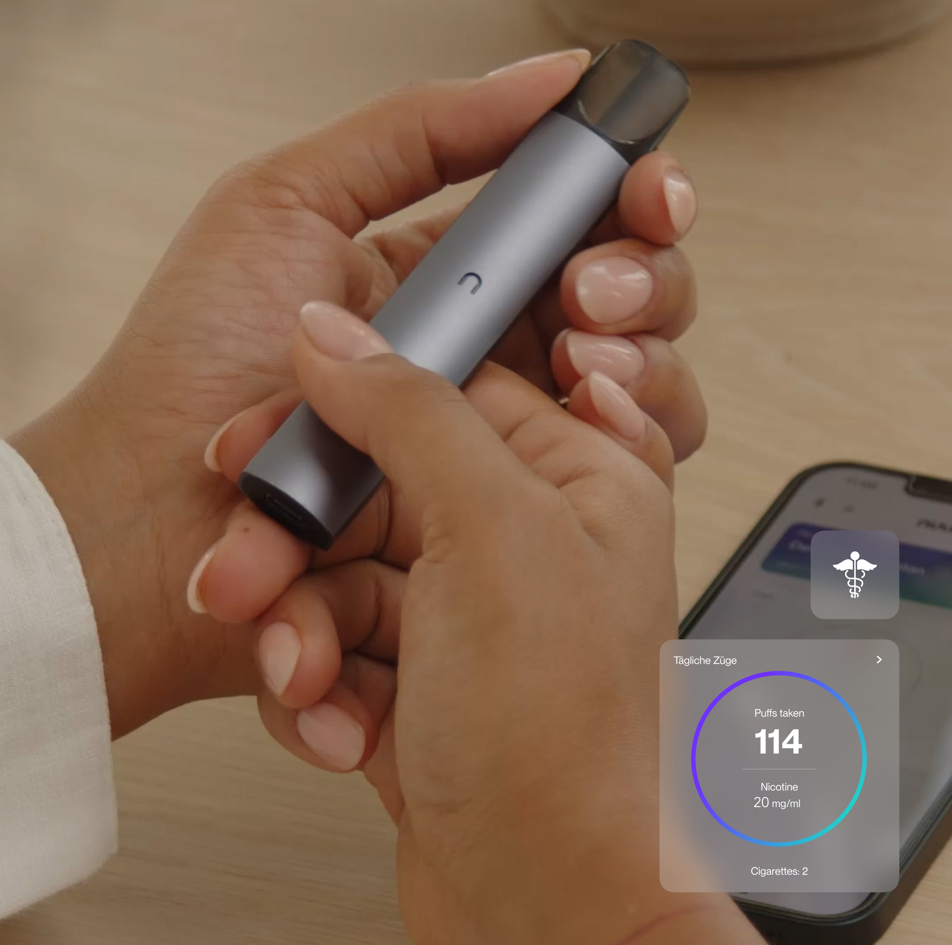 Eine Nahaufnahme von Händen, die die nuumi Vape halten. Im Hintergrund liegt ein Smartphone mit der geöffneten nuumi App. Auf dem Display erscheint ein Fortschritts-Widget, das 114 tägliche Züge und 20 mg/ml Nikotin anzeigt.